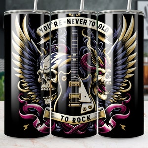 May include: A black and gold tumbler with a graphic of a guitar, wings, and skulls. The text on the tumbler reads "You're Never Too Old To Rock".