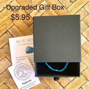 May include: A blue apatite bracelet in a black gift box with a white card that reads "Blue Apatite for manifestation & wisdom". The card also says "Handmade with Love by KC Creations AZ".