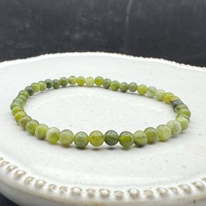 May include: A green jade stone bracelet with round beads.