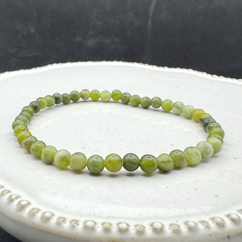 May include: A green jade stone bracelet with round beads.