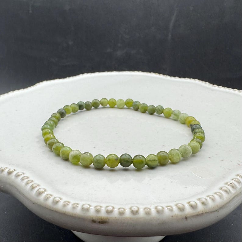 May include: A green jade stone bracelet with small round beads.