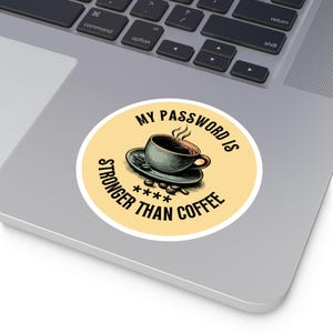 May include: A round sticker with a yellow background and a white border. The sticker features a cartoon illustration of a cup of coffee with steam rising from it. The text "MY PASSWORD IS STRONGER THAN COFFEE" is written in black around the coffee cup. The text "****" is written in black below the coffee cup.