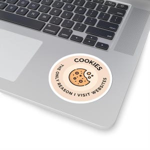 Könnte beinhalten: Ein runder Aufkleber mit hellbraunem Hintergrund und einem weißen Kreis in der Mitte. Der weiße Kreis hat einen schwarzen Umriss und den Text "COOKIES THE ONLY REASON I VISIT WEBSITES" um den Rand herum. In der Mitte des weißen Kreises befindet sich ein Cartoon-Bild eines braunen Kekses mit einem Bissen.