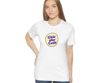 Puede incluir: Camiseta blanca con un círculo amarillo y el texto "Girls Who Code" en morado.