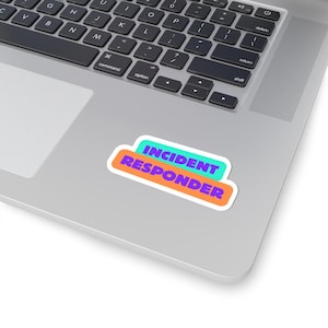 May include: A sticker with the words "INCIDENT RESPONDER" in purple text on a teal and orange background.
