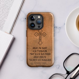 May include: A wooden phone case with a cross and a quote in Cyrillic script. The quote reads "Ако је Бог са тобом чега се бојиш ако није чему се надаш - патријарх павле - "