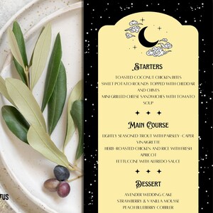 May include: A menu with a black background and a light yellow panel featuring a crescent moon and stars. The menu lists starters, main courses, and desserts. Olive branches and a plate are in the background.