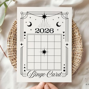 May include: A black and white bingo card with a celestial design. The card features the year "2026" at the top, a grid for bingo numbers, and the words "Bingo Card" at the bottom. The card is decorated with stars, moons, and geometric shapes.