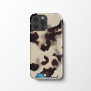 May include: A brown and white tortoiseshell phone case with a blue accent. The case has a pattern of brown swirls on a white background.