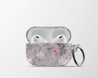 May include: A white Airpods case with a floral pattern featuring pink and white roses on a grey background. The case has a silver ring attached to it.
