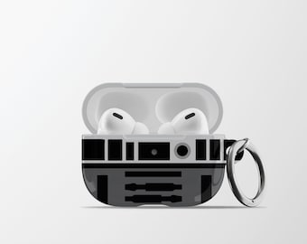 May include: A grey and black protective case for AirPods Pro, featuring a droid-like design. The case is open, showing two white earbuds. A silver metal ring is attached for portability.