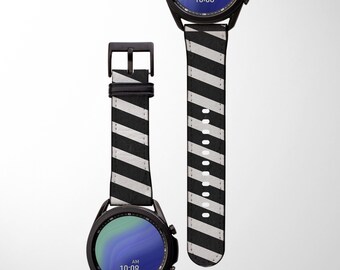 May include: Black and white striped watch band with a black buckle. The watch band is made of leather and has a diagonal stripe pattern.
