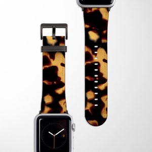 May include: A brown and black patterned Apple Watch band with a black buckle.