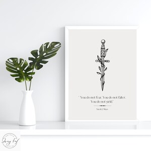 May include: A black and white illustration of a sword with vines growing around it. The quote "You do not fear. You do not falter. You do not yield." by Sarah J. Maas is printed below the image.