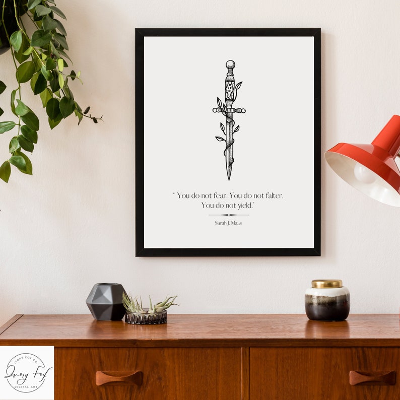 May include: Black and white printable art print featuring a stylised dagger with vines wrapped around it. The print includes the quote "You do not fear. You do not falter. You do not yield." by Sarah J. Maas.
