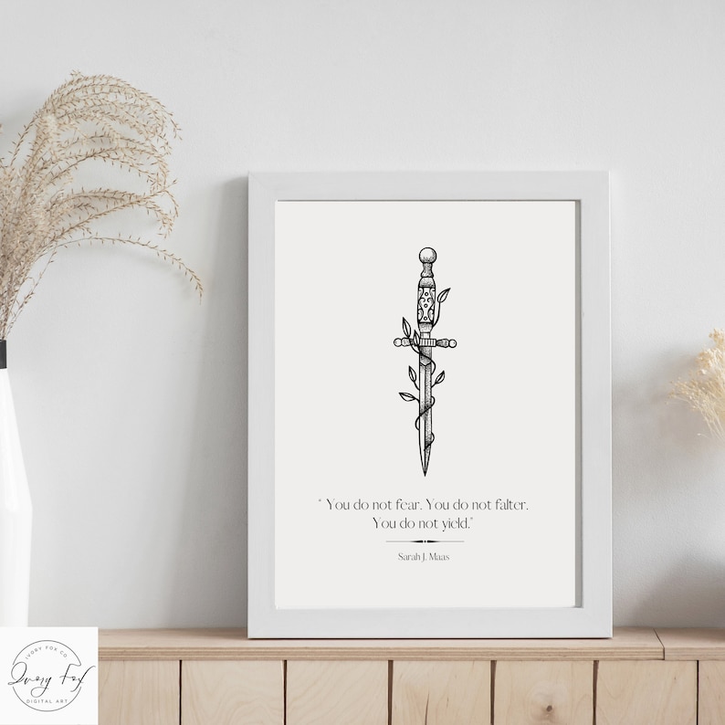 May include: A black and white illustration of a dagger with vines wrapped around it. The quote "You do not fear. You do not falter. You do not yield." by Sarah J. Maas is printed below the image.