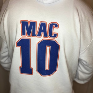 May include: White hooded sweatshirt with the text "MAC" and the number "10" printed on the back in blue and orange.