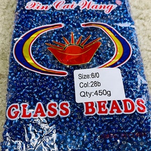 May include: A bag of blue glass beads, labelled "Glass Beads" with a red and yellow logo. The label also includes the details: "Size: 6/0", "Col: 28b", and "Qty: 450g".