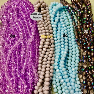 May include: Four strands of 8mm faceted glass beads. The strands are purple, light grey, light blue, and iridescent brown. The text "8MM size beads" is visible in the image.