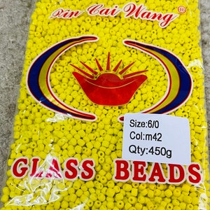 May include: A bag of yellow glass beads, labelled "Rin Cai Wang" and "GLASS BEADS". The bag also includes the details "Size: 6/0", "Col: m42", and "Qty: 450g". The bag is made in China.