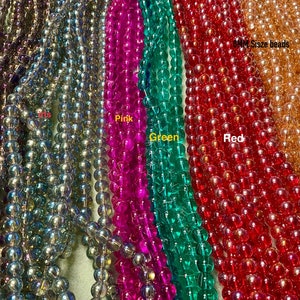 May include: Assortment of iridescent glass beads in various colours, including black, pink, green, red, and gold. The beads are 8mm in size.
