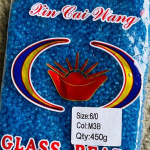 May include: A bag of 450 grams of blue glass beads, labelled "Din Cai Wang" with the size "6/0" and colour "M3B".