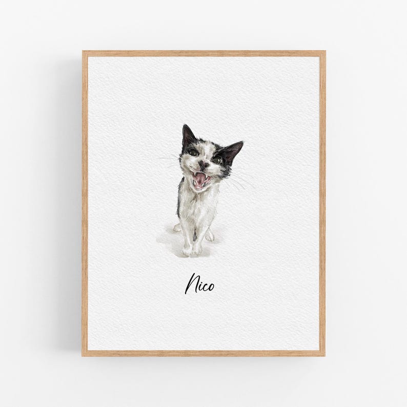 Op de afbeelding: Een aquarel van een zwart-witte kat met een speelse uitdrukking. De kat kijkt recht naar de kijker met zijn mond open. Het schilderij is ingelijst in een licht houten lijst en heeft de naam "Nico" onder de kat.
