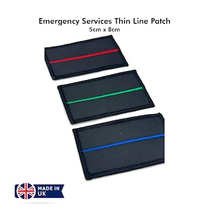 Op de afbeelding: Drie zwarte stoffen patches met dunne gekleurde lijnen. De patches zijn 5 cm bij 8 cm. De lijnen zijn rood, groen en blauw.