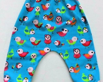 Puede incluir: Pantalones de bebé azules con un estampado de pájaros coloridos y cintura y puños elásticos rojos.