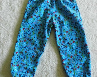 Puede incluir: Pantalones azules y rojos con estampado, cintura elástica ancha y piernas con puños.