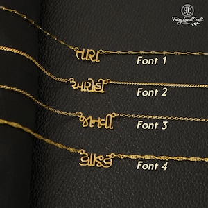 May include: Four gold-toned necklaces with custom name pendants in different scripts, labelled Font 1, Font 2, Font 3, and Font 4. Each necklace features a delicate chain and a unique metal nameplate design, showcasing various typographic styles for personalised jewellery.