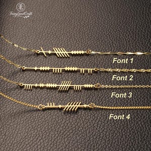 Könnte beinhalten: Vier goldfarbene Halsketten mit verschiedenen Anhängerdesigns. Jede Halskette hat eine zarte Kette und eine einzigartige Anhängerform, einschließlich Pfeil- und Linienmustern. Der Text "Font 1", "Font 2", "Font 3" und "Font 4" ist sichtbar.
