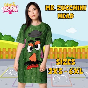 Puede incluir: Vestido de camiseta verde con una imagen de dibujos animados de Mr. Zucchini Head. El vestido tiene mangas cortas y cuello redondo. El texto "MR. ZUCCHINI HEAD" y "SIZES 2XS - 6XL" están impresos en el vestido.