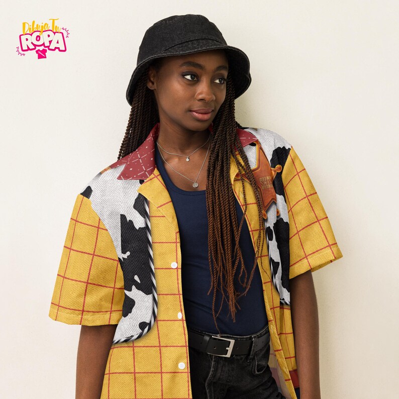 May include: A yellow plaid short-sleeve shirt with a cow print design and a sheriff badge. The shirt is paired with a black denim bucket hat and a navy blue top. The image includes the text "Dibuja Tu Ropa".