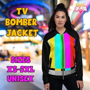May include: Black unisex bomber jacket with a colorful TV test pattern design on the front. The jacket has a zipper closure and black sleeves. Text on the image reads "TV BOMBER JACKET" and "SIZES XS-3XL UNISEX".