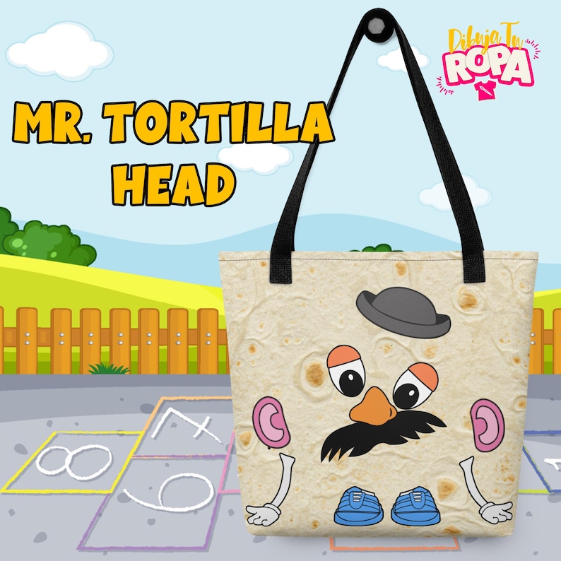 May include: A beige tote bag featuring a cartoon tortilla character with a hat, mustache, and shoes. The bag has black handles and the words "MR. TORTILLA HEAD" in yellow. The background shows a park scene.
