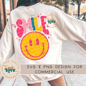 May include: A white sweatshirt with a colorful "SMILE" graphic and a yellow smiley face. The graphic has a distressed, vintage look. The text "Creative Digital Entrepreneur" is on the left sleeve and "Uari Love" is on the right sleeve. The text "SVG & PNG Design for Commercial Use" is at the bottom of the image.