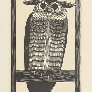 May include: A black and white woodcut print of an owl perched on a branch. The owl is looking directly at the viewer with large, round eyes. The print is framed in a simple black frame. The artist's signature and date are visible in the bottom right corner.