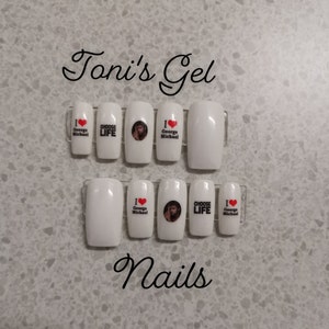 May include: Set of six white press-on nails with different designs. The designs include a portrait of George Michael, the words "I Love George Michael", and "Choose Life".