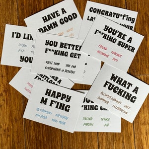 May include: A set of 10 greeting cards with humorous and sarcastic messages. The cards are white with black text and feature phrases like "Have a Damn Good Day", "You Better F**king Get Well Soon", and "What a F**king Accomplishment".