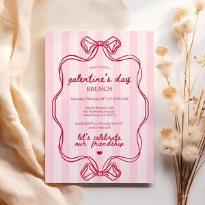 May include: A pink Galentine's Day brunch invitation with vertical stripes. The invitation features red text and decorative ribbon designs. The text reads "Join us for a Galentine's Day Brunch" and includes event details.