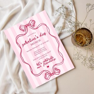 May include: Pink and white striped Galentine's Day brunch invitation. The invitation features a decorative frame with bows and the text "galentine's day BRUNCH". Includes event details: date, time, location, and RSVP information.