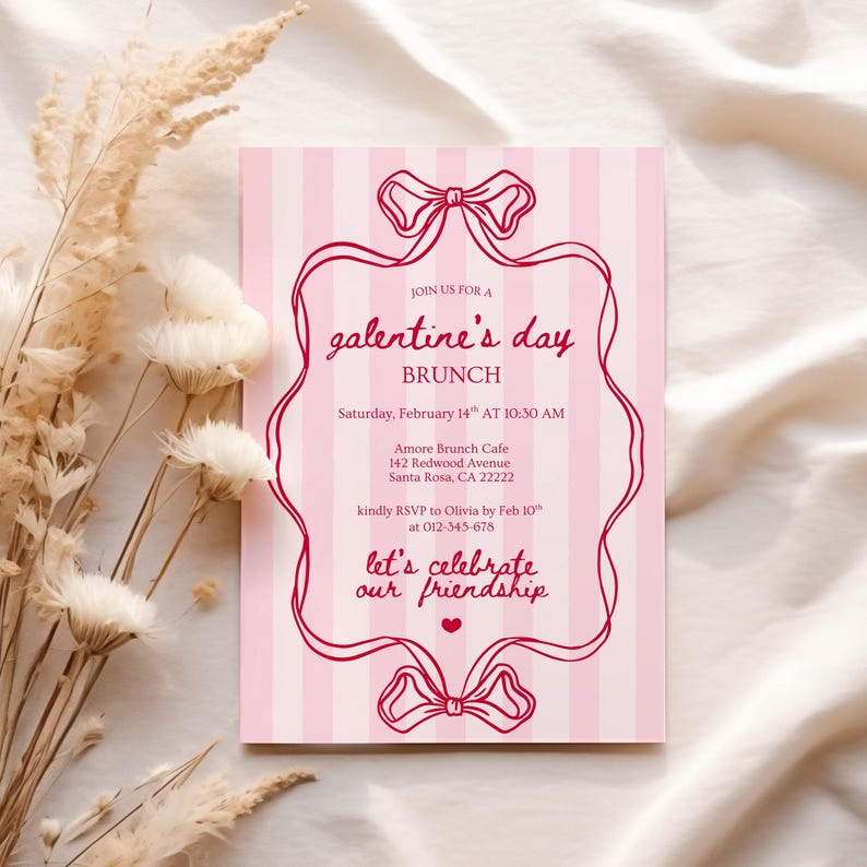 May include: A pink and white striped Galentine's Day brunch invitation. The invitation features a decorative red bow design and text that reads "Join us for a Galentine's Day Brunch" with event details. The invitation is on a white surface with dried flowers.