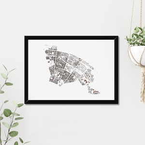 May include: A black framed print of a detailed map of a city. The map is in shades of brown and white and shows the layout of the city's streets and buildings.