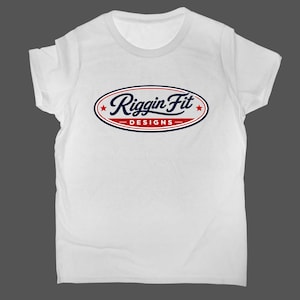 May include: A white short-sleeved t-shirt featuring a central oval logo. The logo contains the blue cursive text Riggin Fit above the red block text DESIGNS, flanked by two small red stars, all enclosed within a blue and red oval border.