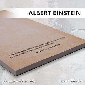 May include: A brown notepad with a quote by Albert Einstein: "A calm and modest life brings more happiness than the pursuit of success combined with constant restlessness." The notepad is 5.5 inches by 8.5 inches and has 50 sheets.