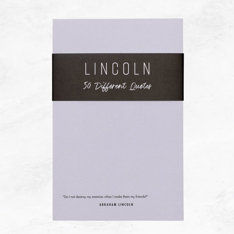 Elusive Blue colored notepad with a black belly band that says: Lincoln 50 Different Quotes. An Abraham Lincoln quote about enemies is written across the bottom in a modern font.