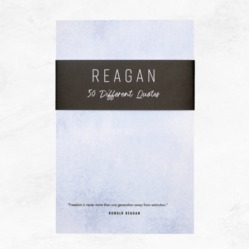 Light blue textured notepad with a black belly band that says: Reagan 50 Different Quotes. A Ronald Reagan quote about freedom is written across the bottom in a modern font.