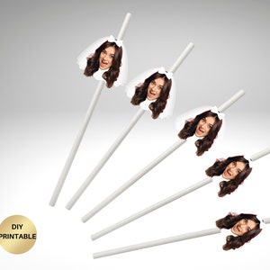 May include: White paper straws with a bride's face attached. The bride is wearing a white veil and has long brown hair. The straws are arranged at different angles against a gray background. The text "DIY PRINTABLE" is in a gold circle.