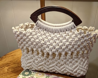 Precioso bolso de mano macramé con asas ovaladas de madera.